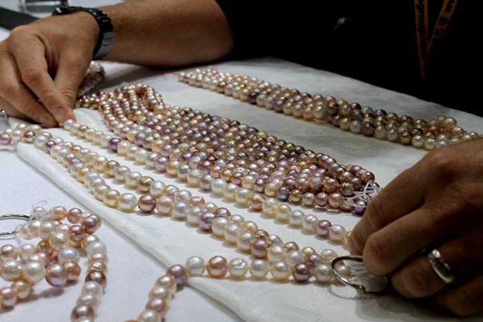examining multiple strands of multi-colored ripple pearls