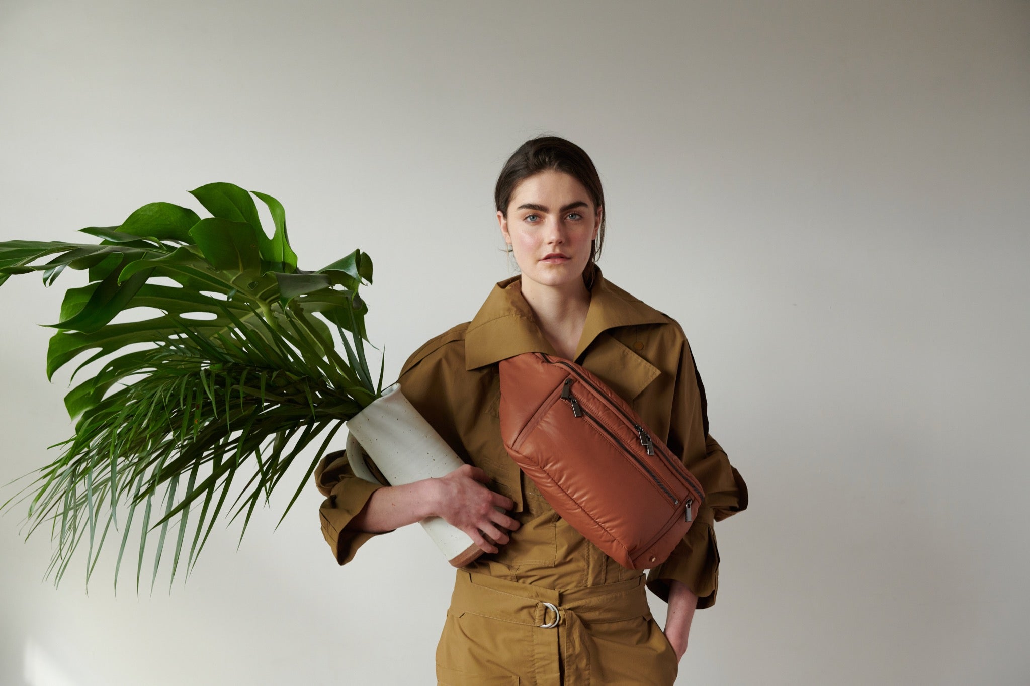 A model in a beige outfit also wears a crossbody bag designed by Caraa. 