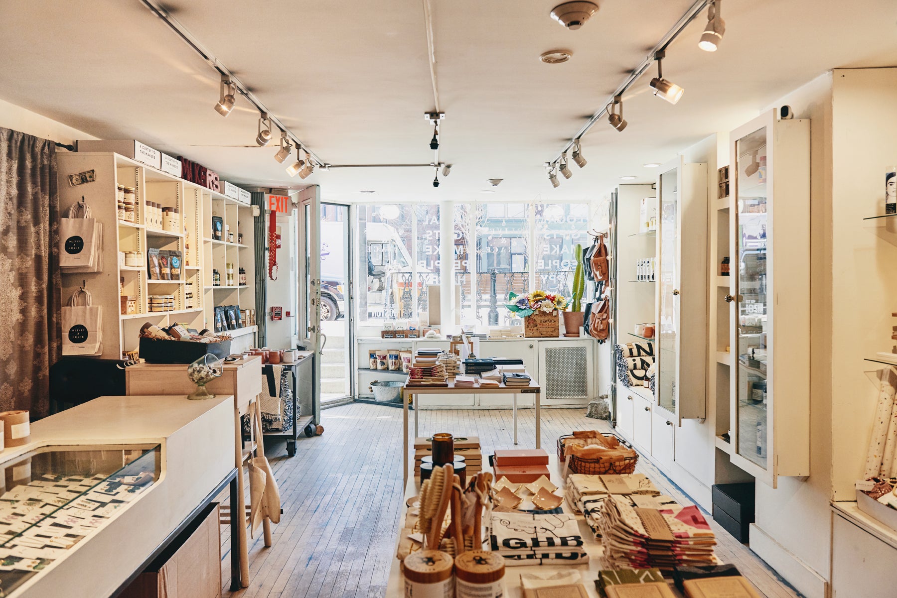 Wide image of the inside of Olives & Grace, showing shelves and tables merchandised with lifestyle goods.