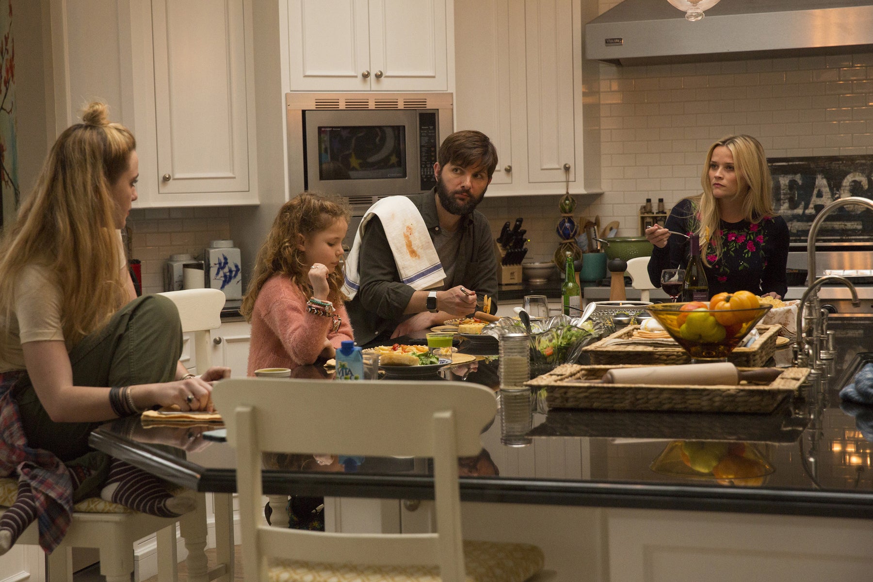 Madeline and Ed (Adam Scott) prepare dinner in the kitchen for their daughters, Abigail (Kathryn Newton) and Chloe (Darby Camp).
