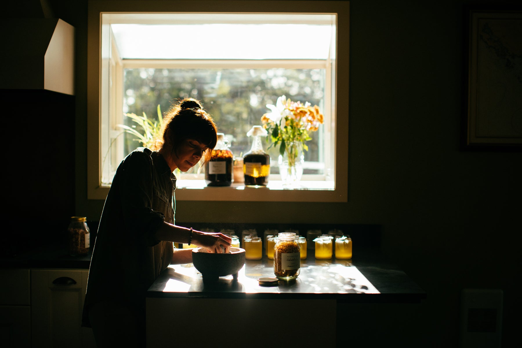 At her workspace, Angela L'Heureux uses a stone mortar and pestle to grind her ingredients by hand.  
