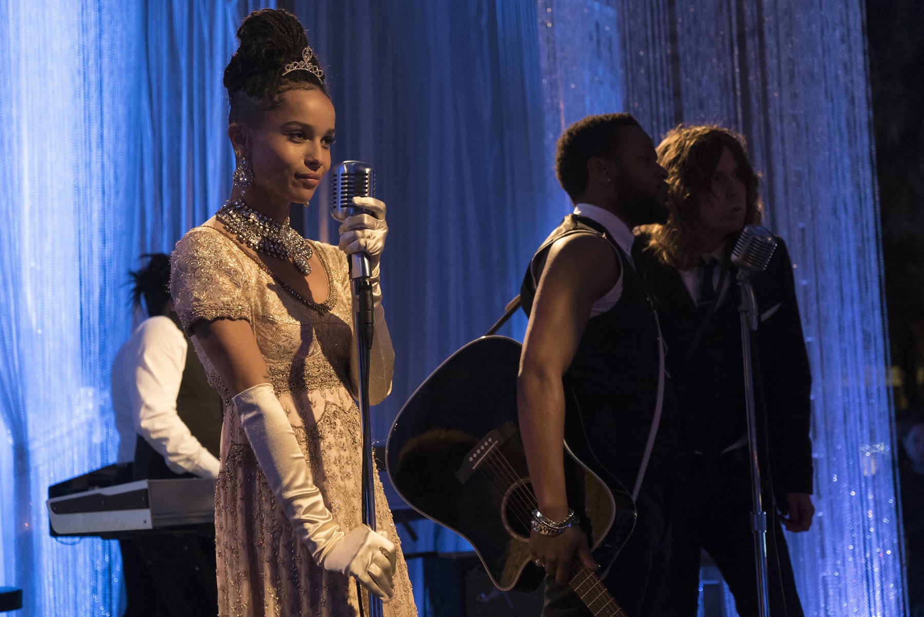 Bonnie (Zoe Kravitz) performs at the Audrey Hepburn–themed party, dressed as Audrey in My Fair Lady.