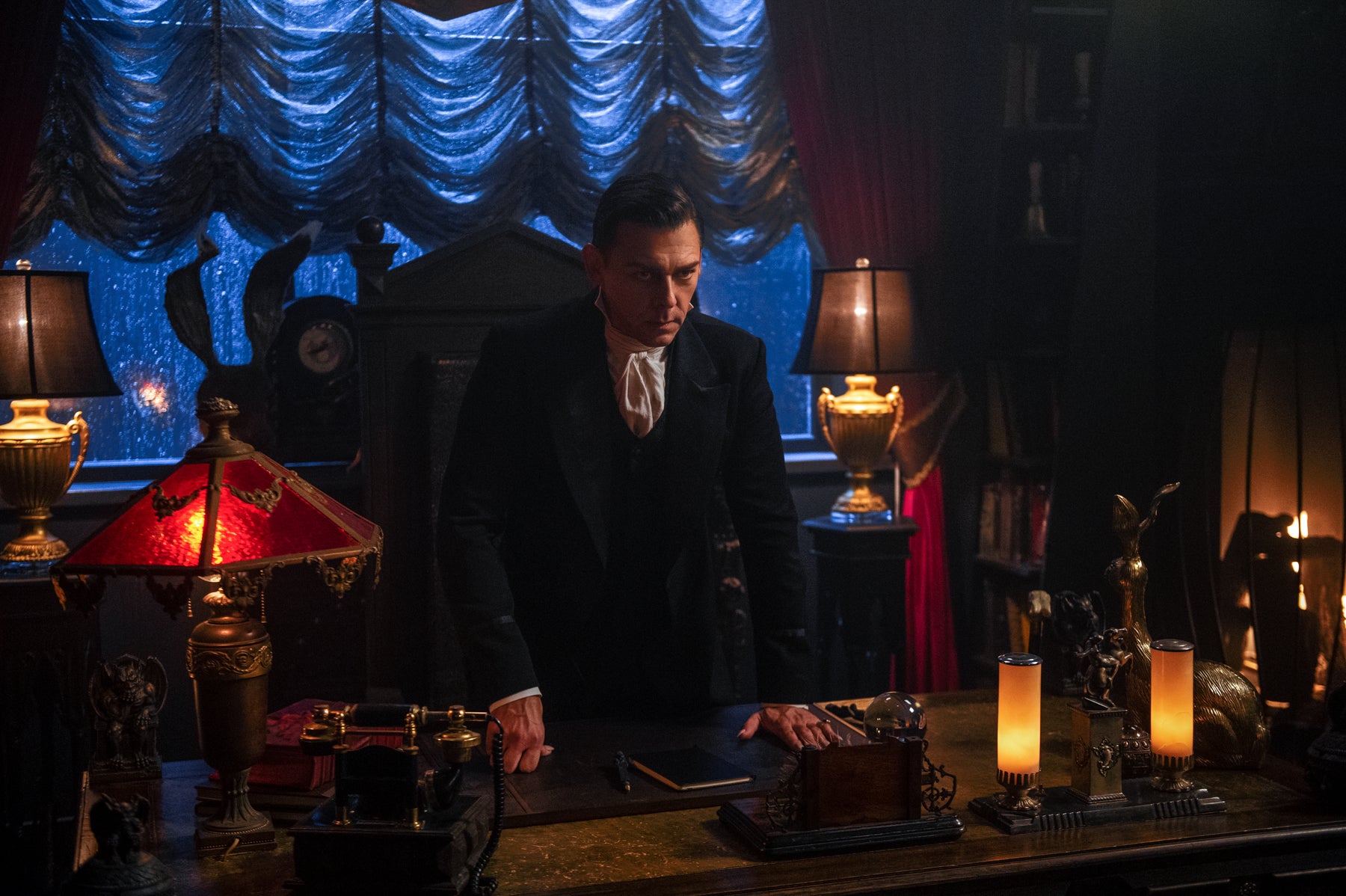 Father Blackwood stands at his desk in his office at the academy in a scene from Chilling Adventures of Sabrina.