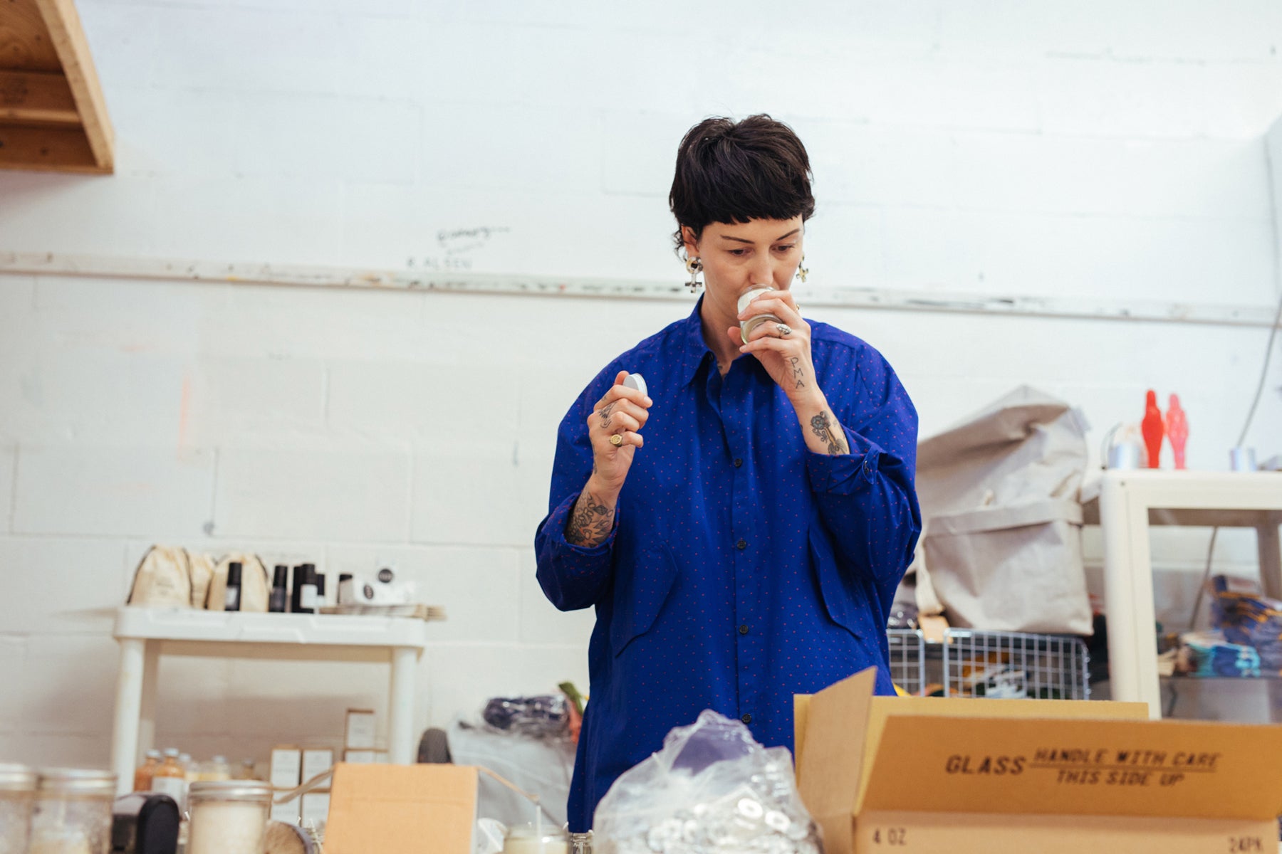 Kerry Butt in her Red Sky Candles studio, smelling one of her handmade candles.