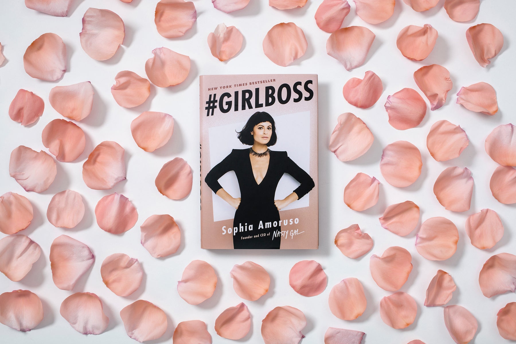 #Girlboss, a book by Sophia Amoruso, surrounded by pink rose petals.