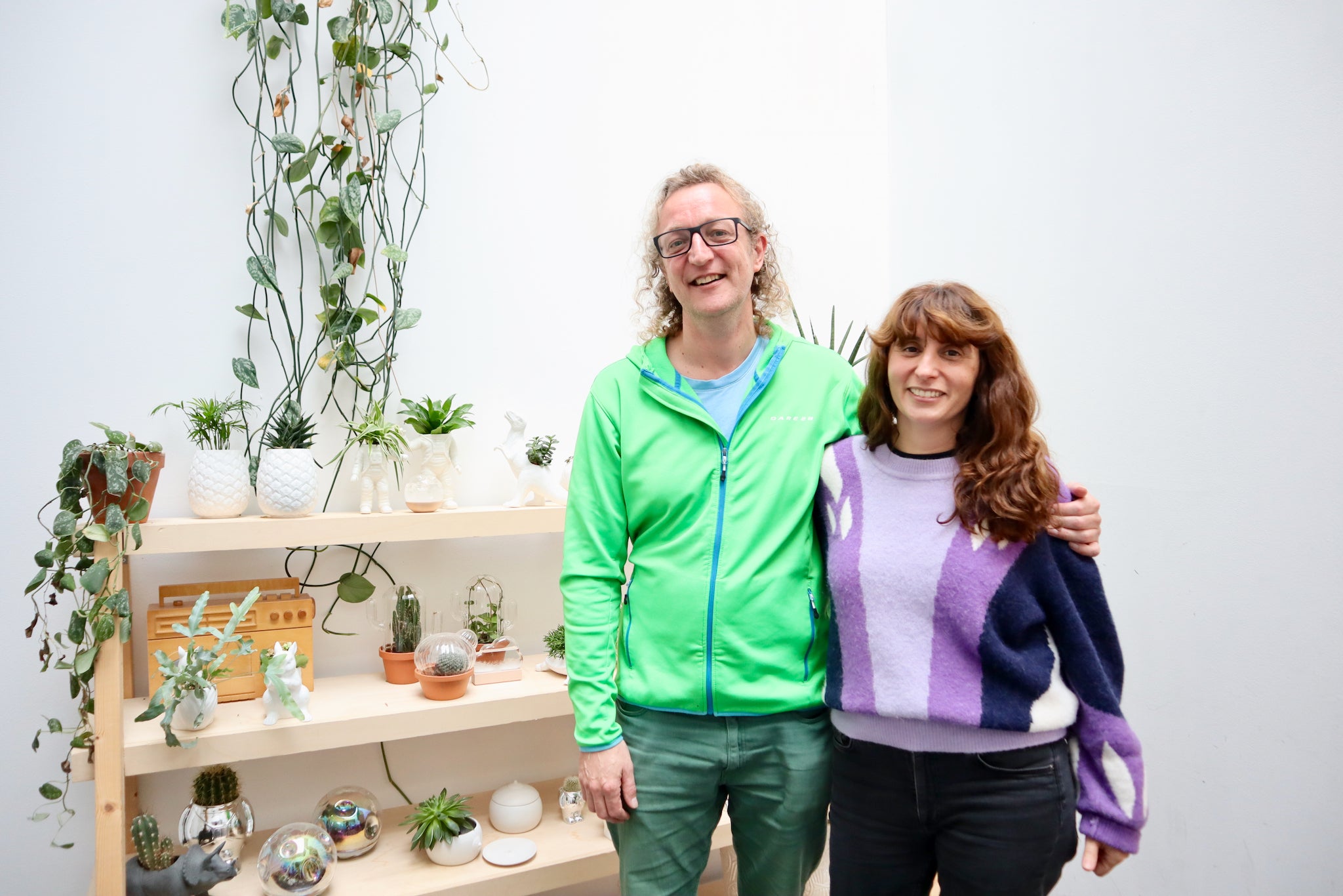 Diana Paisis and Al Cutell standing in front of a shelf filled with their designs in the Bitten Design office.