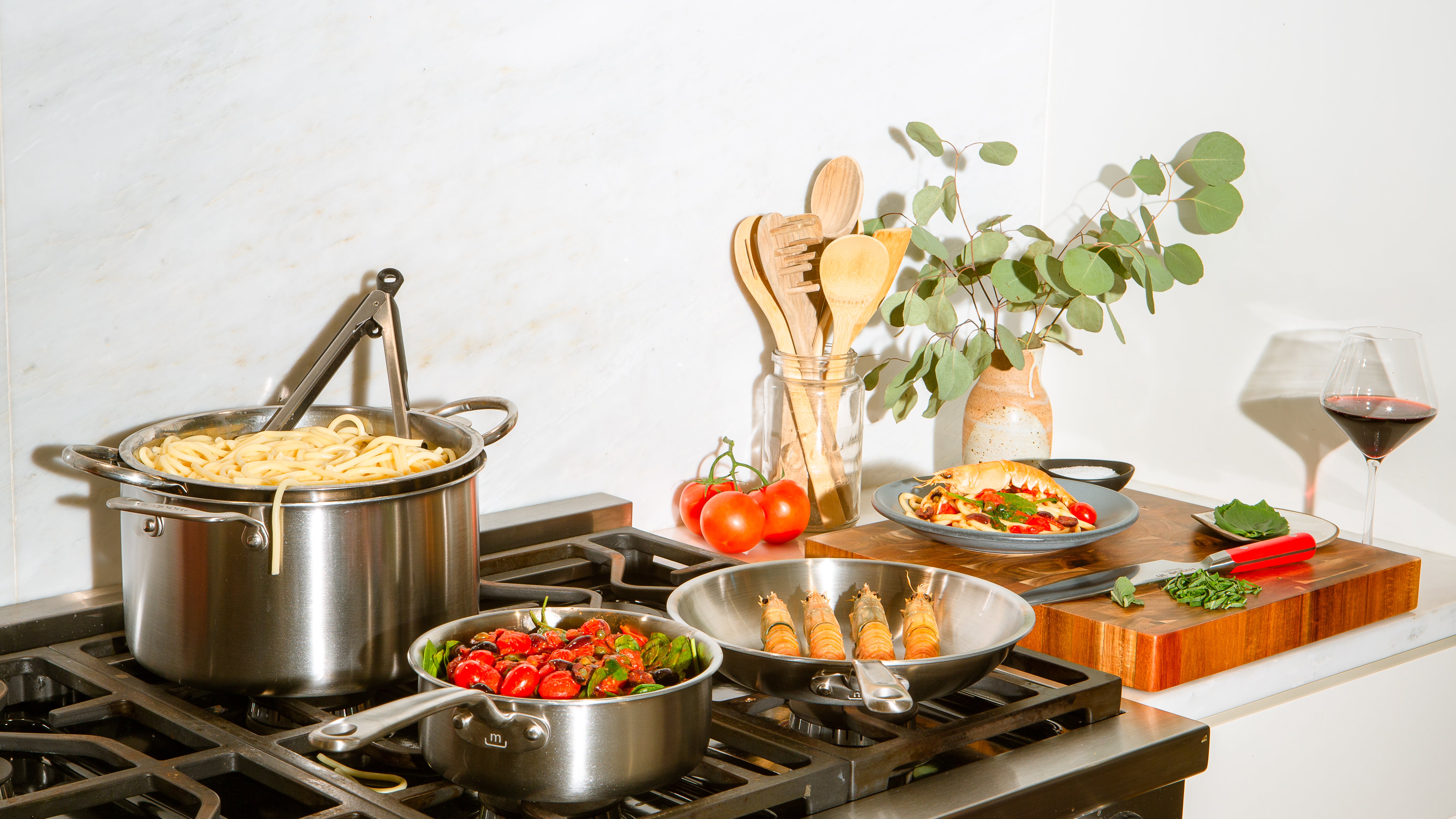 Selection of pots and pans by Made In being used to cook up a seafood pasta meal. 