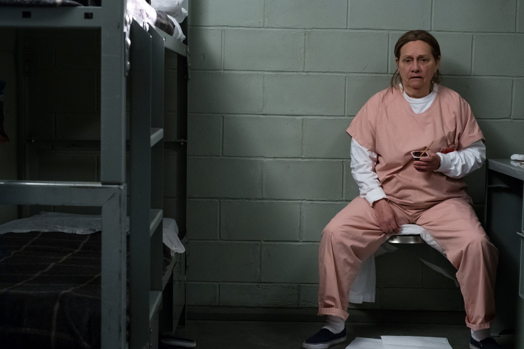 Frieda Berlin sits alone in a prison cell in an episode of Orange Is the New Black.
