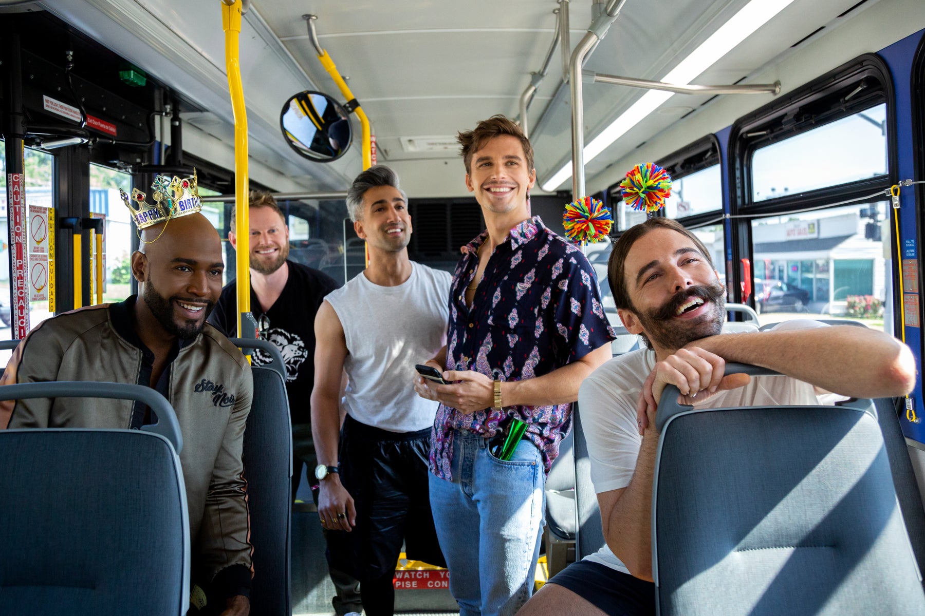 Karamo, Bobby, Tan, Antoni, and Jonathan stand on a public bus, looking off camera in an episode of Queer Eye.