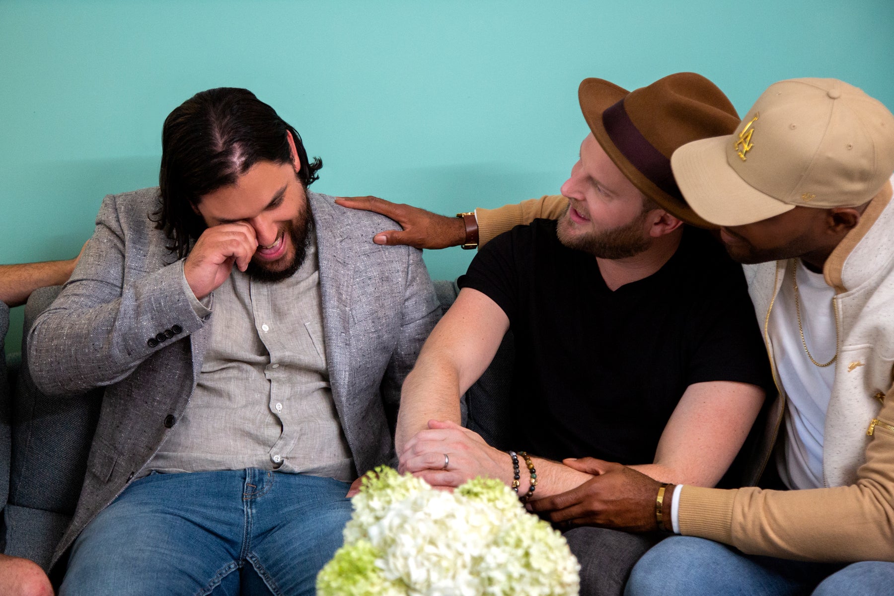 Bobby and Karamo sit on a couch comforting a crying man in an episode of Queer Eye.