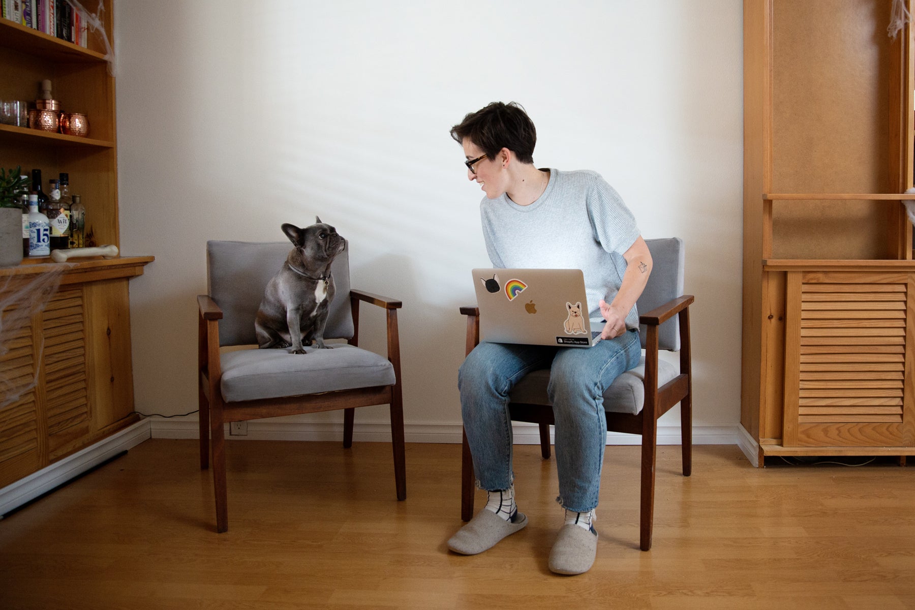 Passionfruit founder Liz Bertorelli sits with her laptop. Her french bulldog Olive sits beside her.