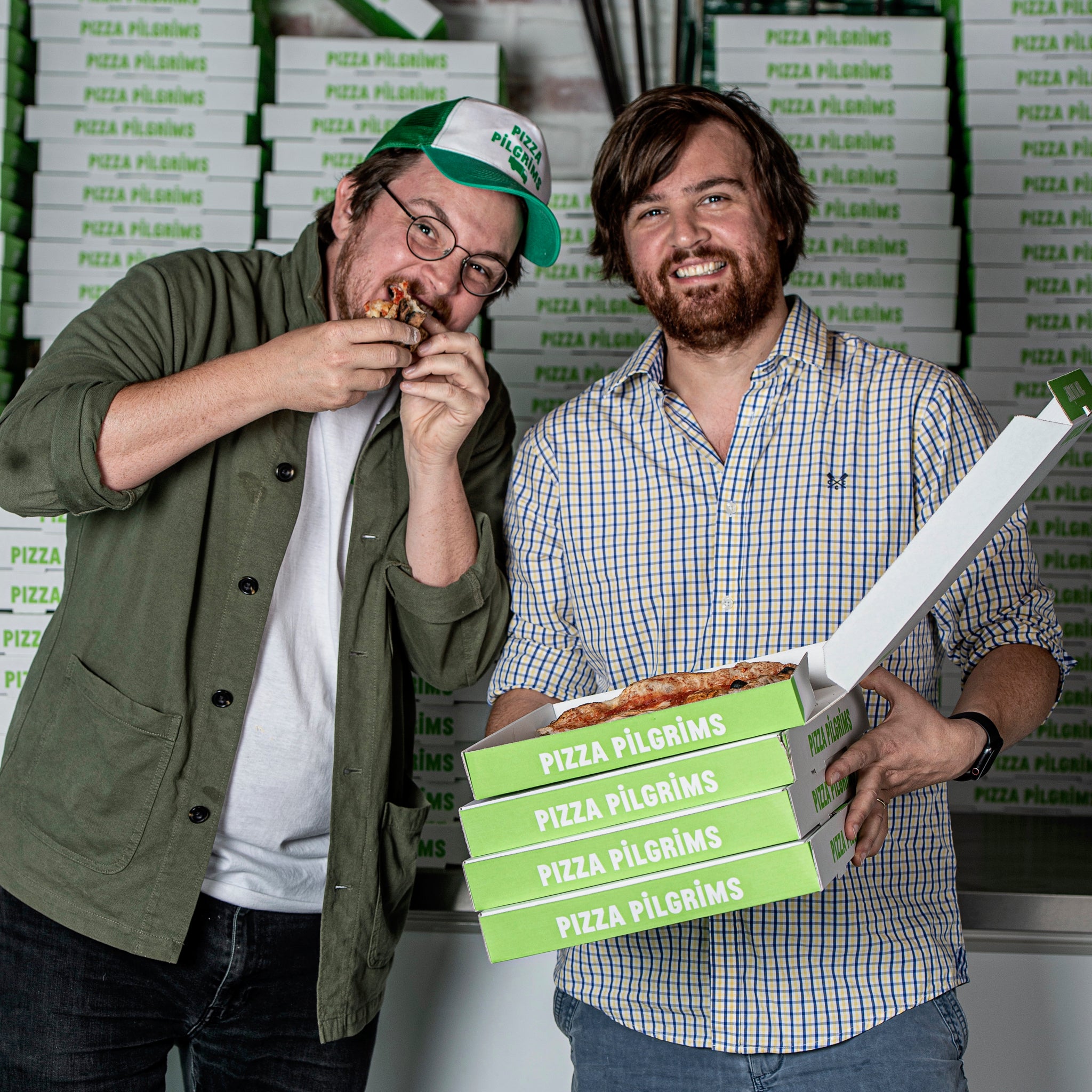 James and Thom Elliot surrounded by countless pizza boxes from Pizza Pilgrims. 