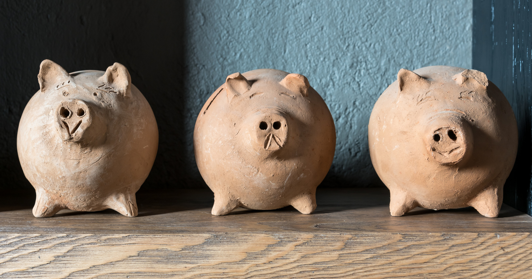 3 worn-looking terra cotta piggy banks: business banking products for new SMBs