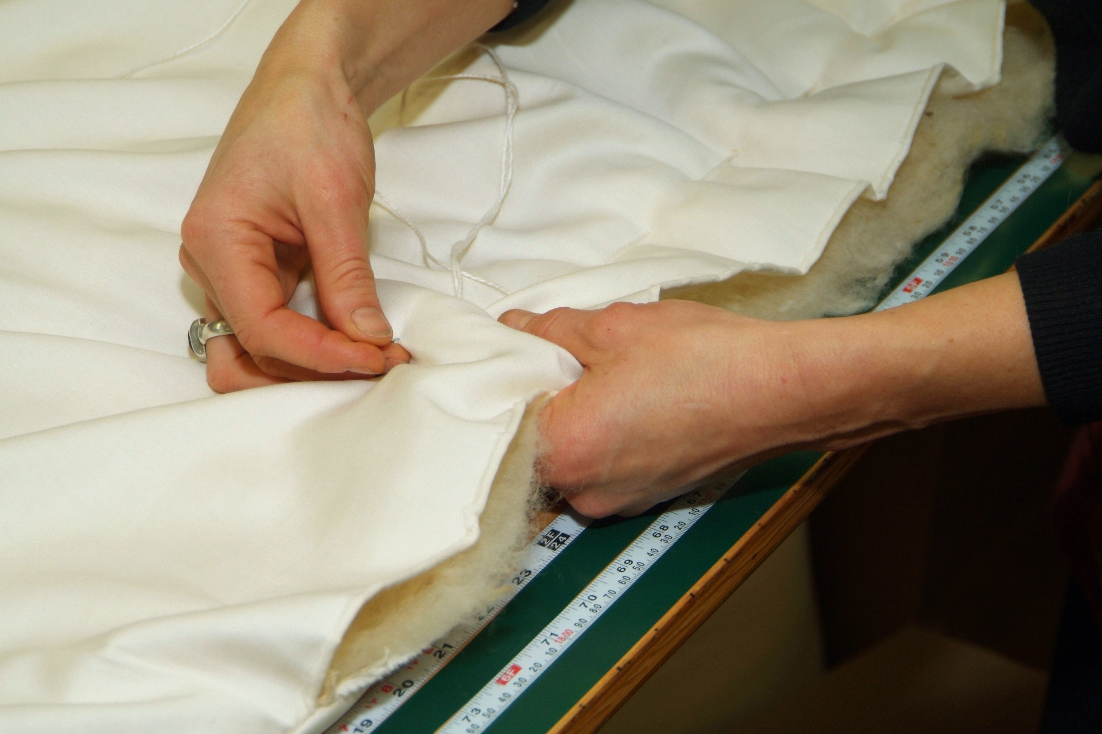 A maker sews a piece of bedding at Holy Lamb Organics.
