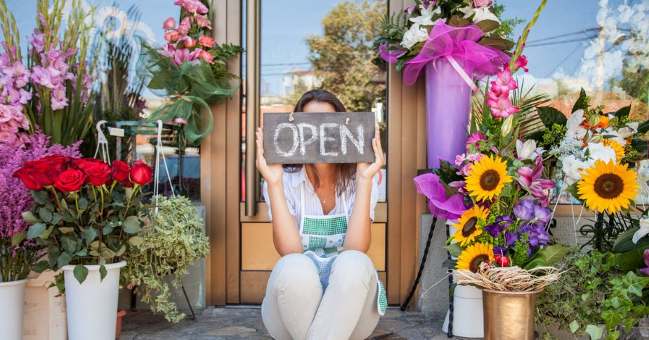 Woman sitting outside of the small business she started