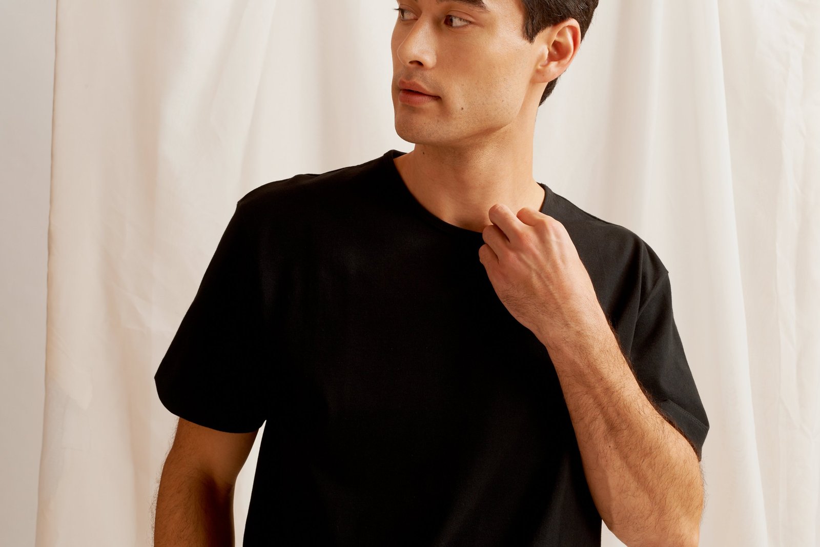 Man wearing a plain black cotton t-shirt by KOTN