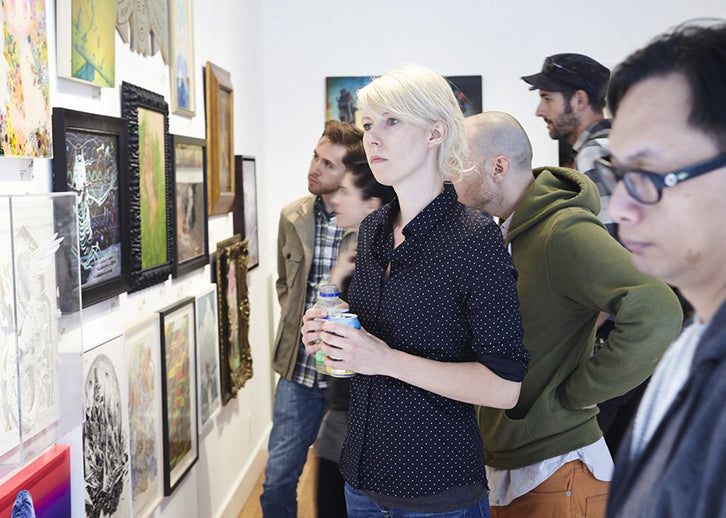 Bild, auf dem eine Frau in einer Kunstgalerie zu sehen sind. Es geht um Möglichkeiten, wie man Kunst verkaufen kann.