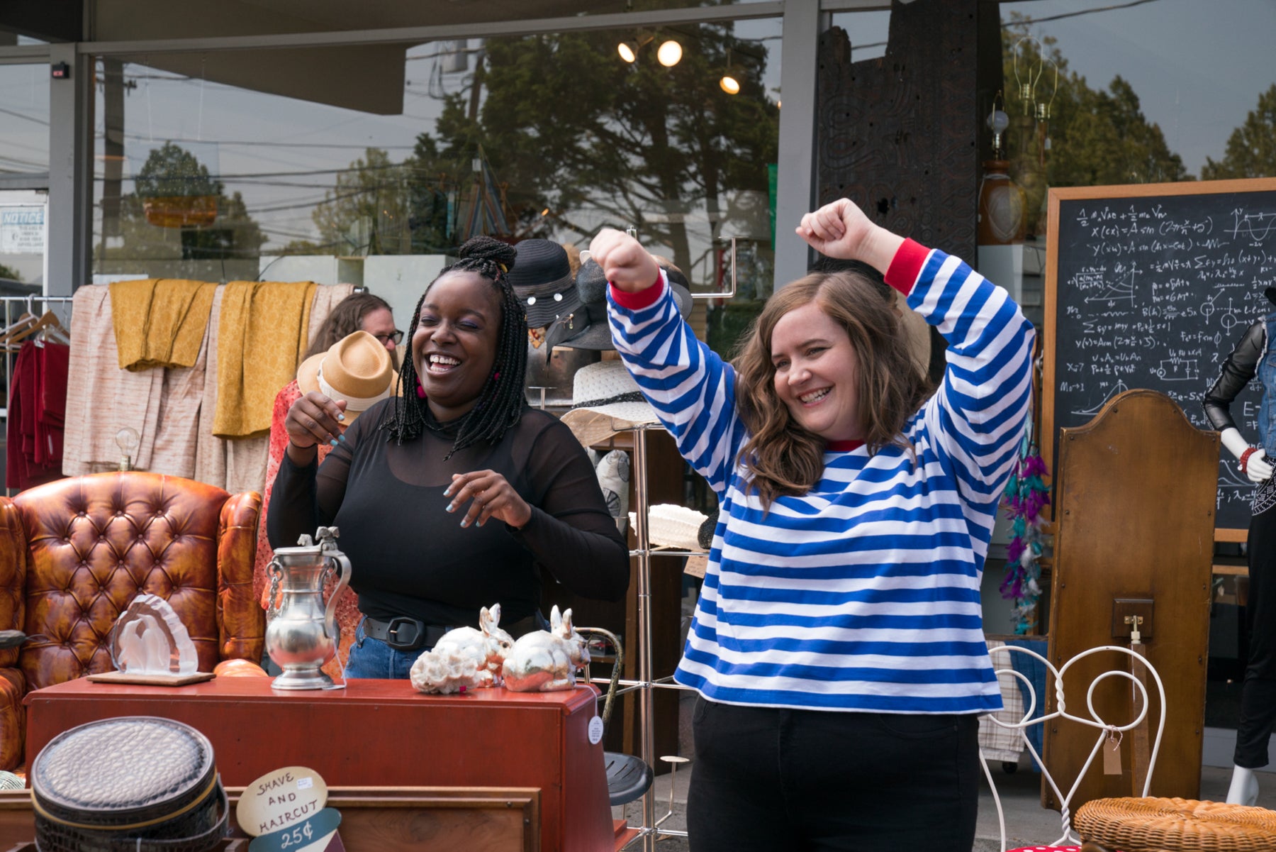 Annie and her roommate laugh and dance at an outdoor antique sale. 