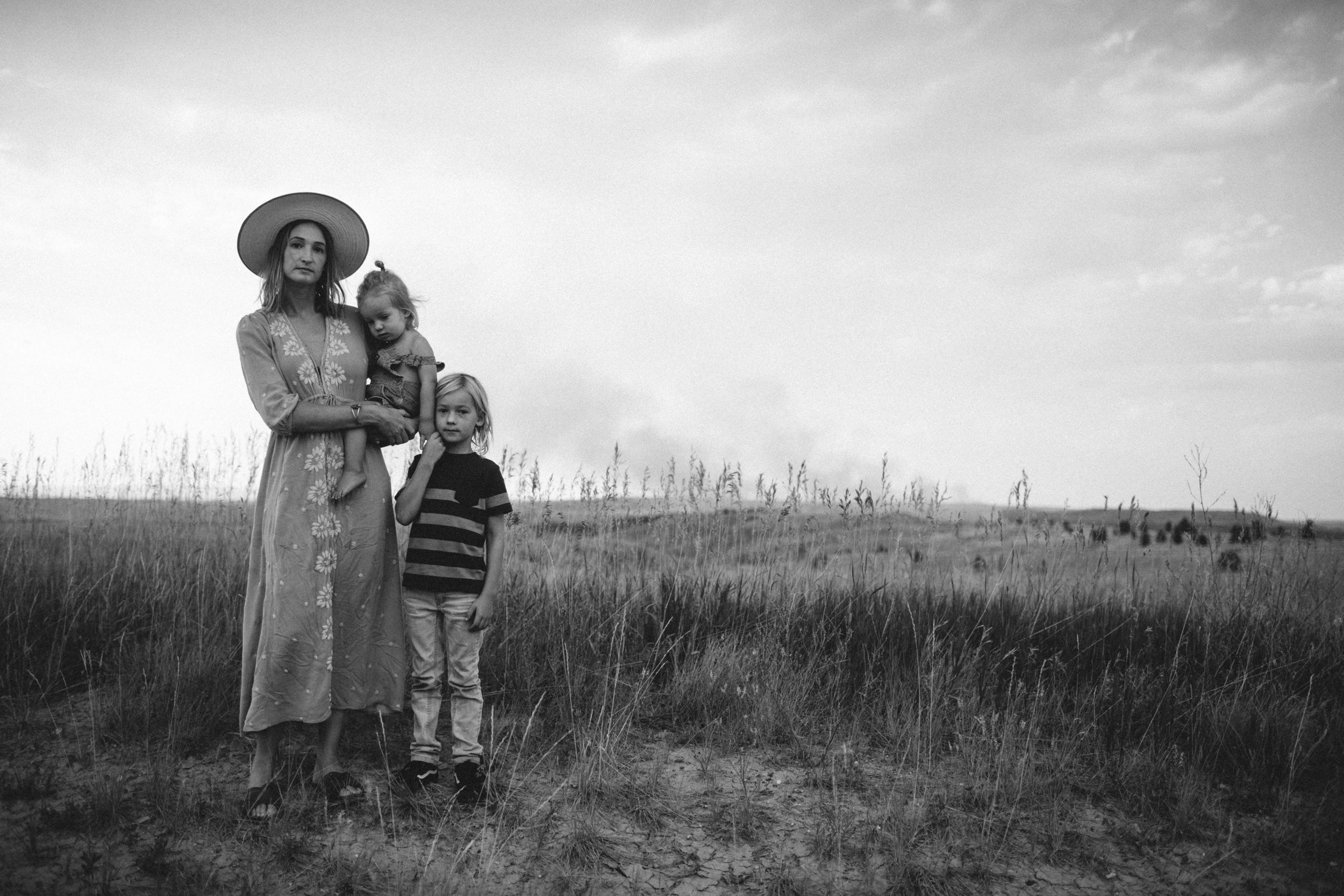 Portret van Ashley Jennett die met haar kinderen in een veld staat