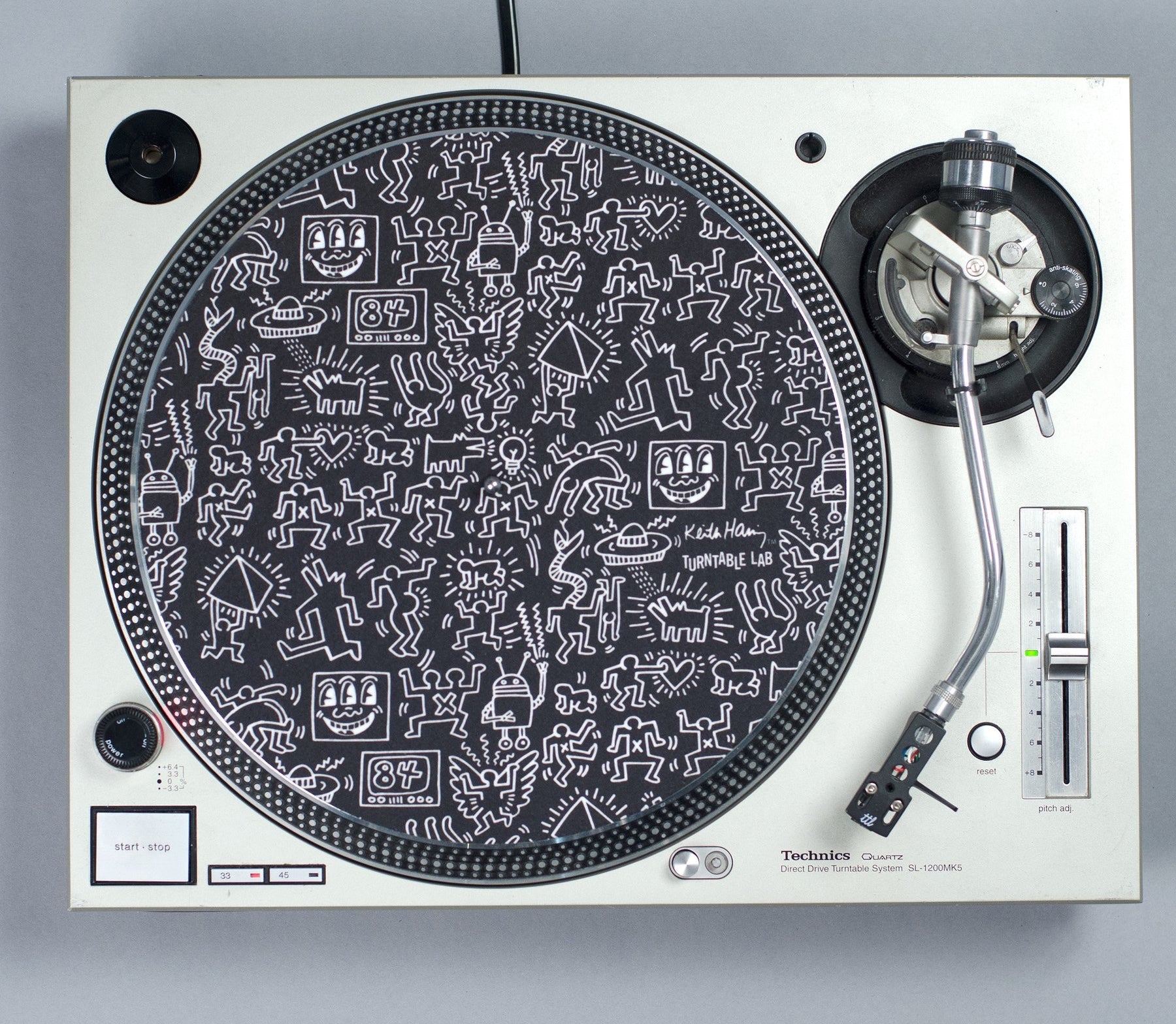 Shot from above, a turntable with a Keith Haring vinyl mat