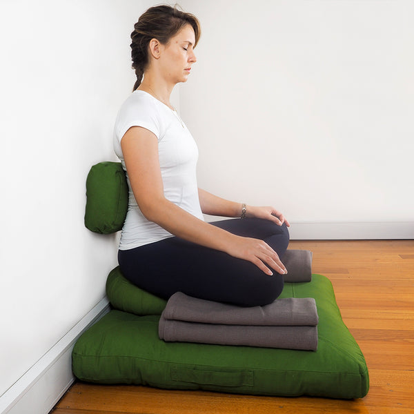 If leaning against a wall, a lumbar support such as a rectangular zafu can make your posture more easeful.