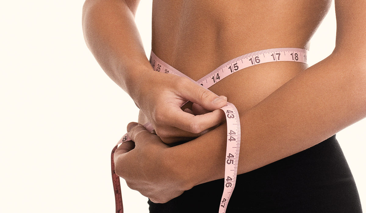 woman measuring waistline