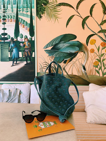 teal block printed suede llani handbag in front of a hand painted wall in jaipur india