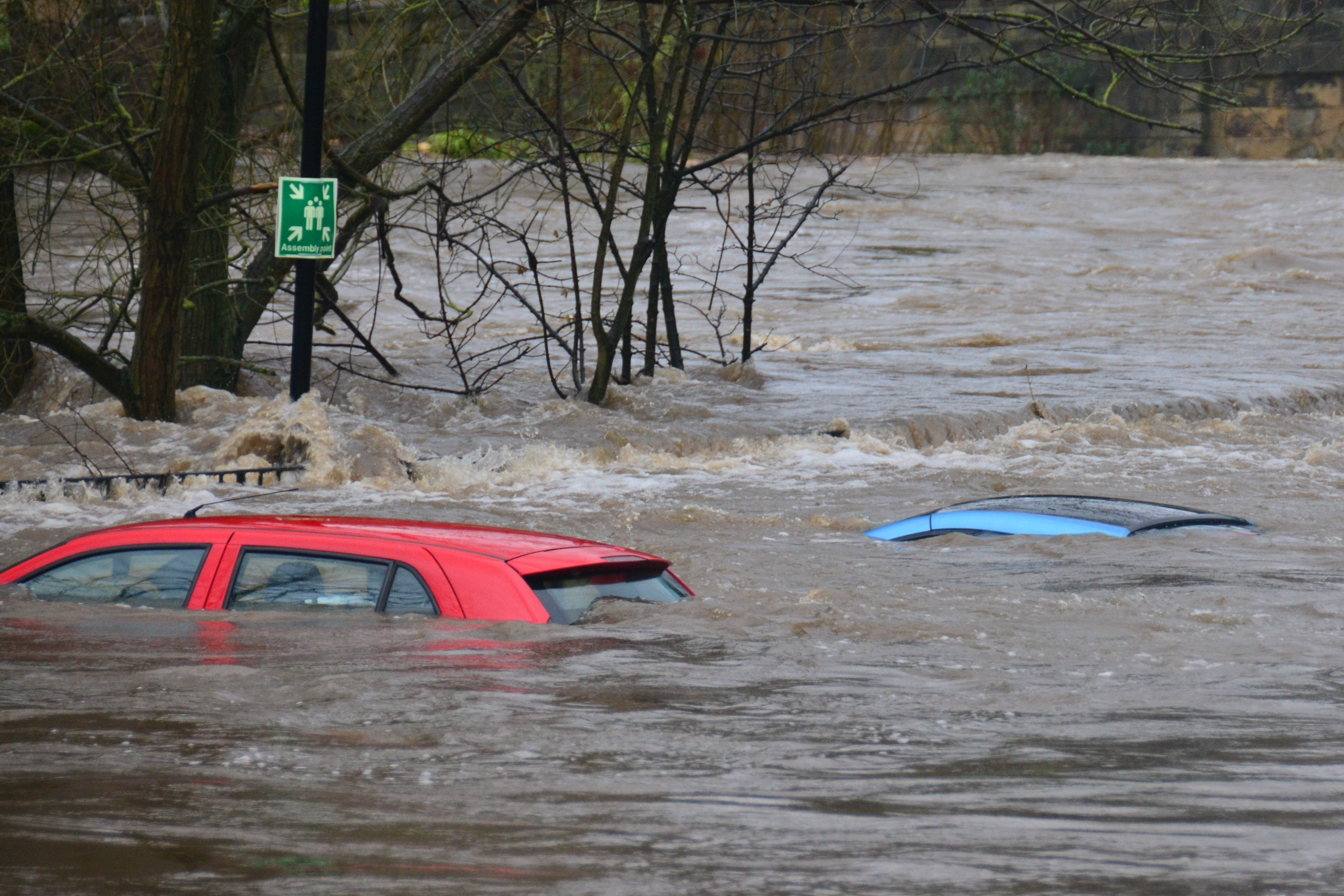 Two cars submerged in flood waters except for their roofs