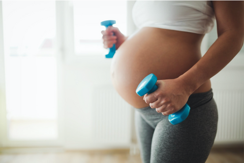 pregnant woman blue dumbbells working out
