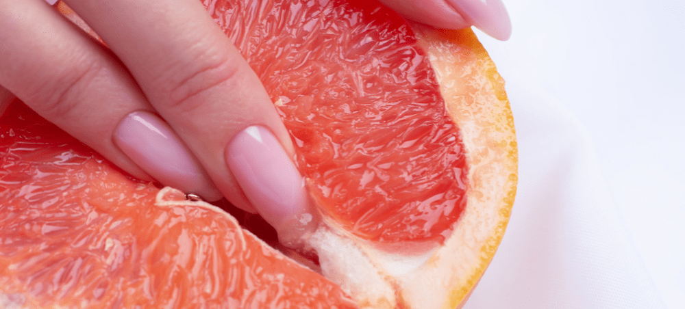 Image of woman fingering fruit that looks like a clitoris