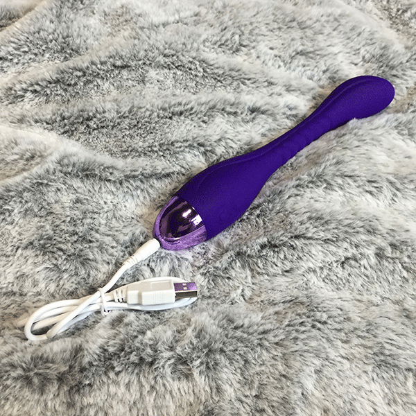 Purple G Spot Vibrator Shown With Charger Plugged In At The Bottom Of Toy