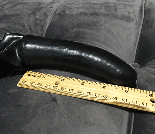 Strap on dildo placed next to ruler
