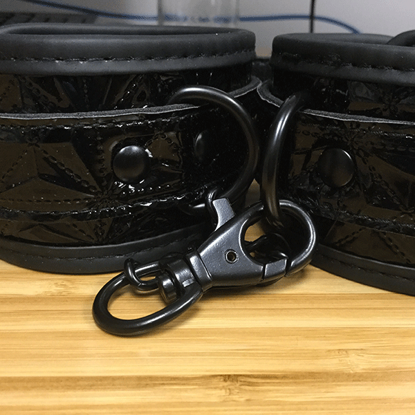 Detailed Picture Showing The Black Handcuffs And The Black Chain