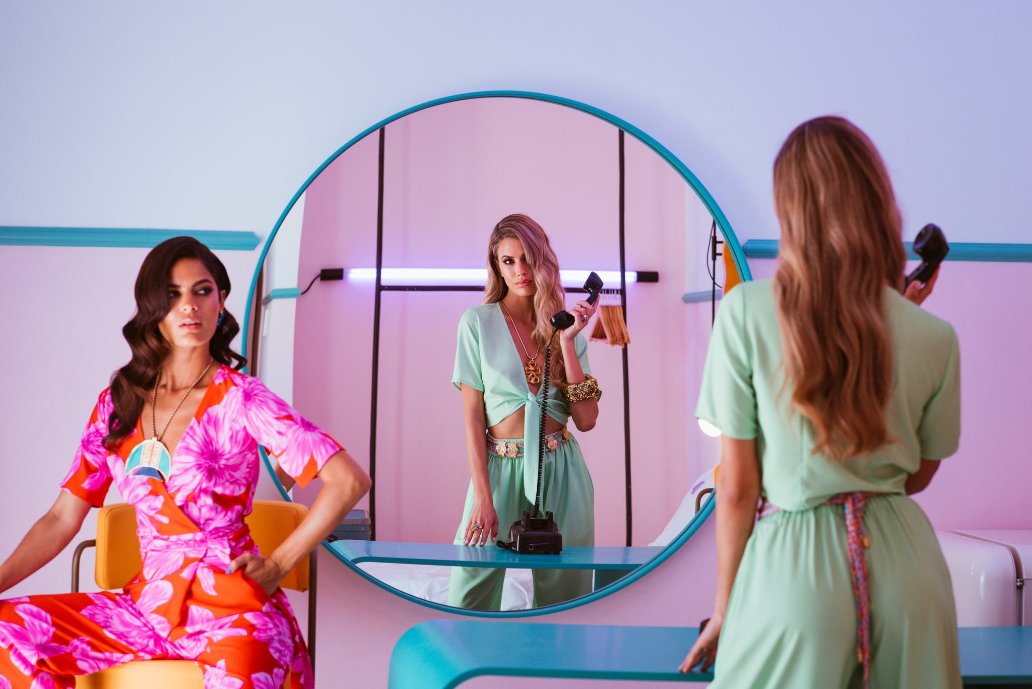 models wearing Dancing Leopard, one sat down other on old style telephone looking in mirror