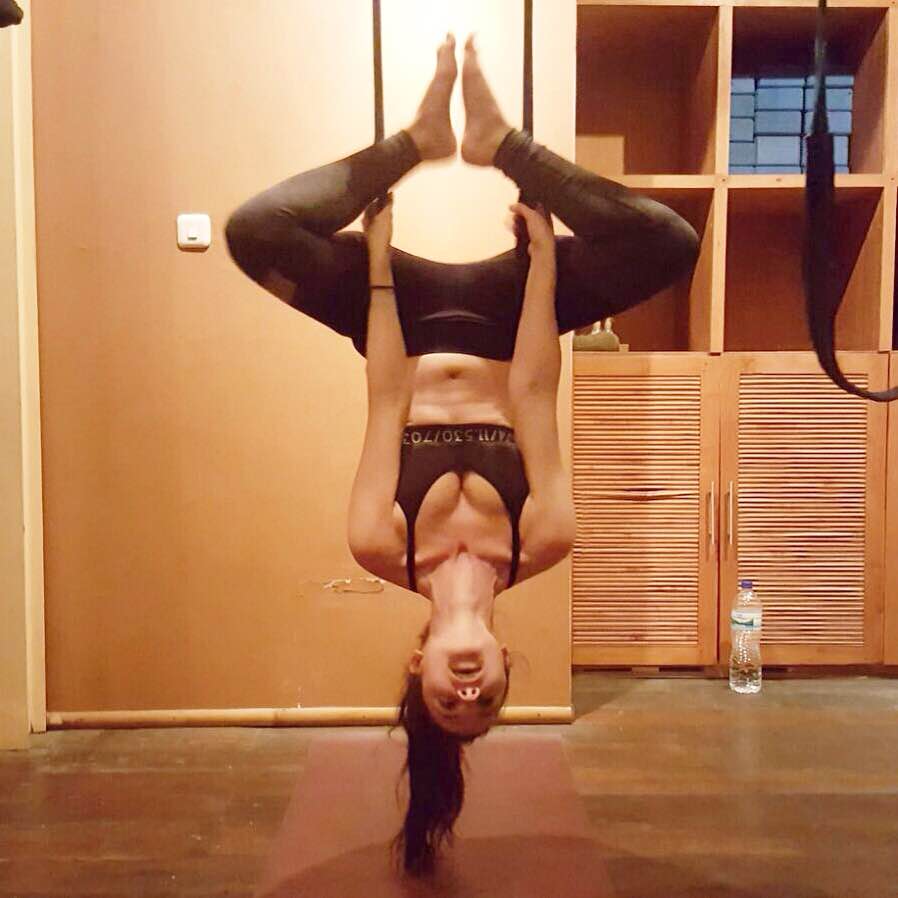 Sarah doing aerial yoga upside down