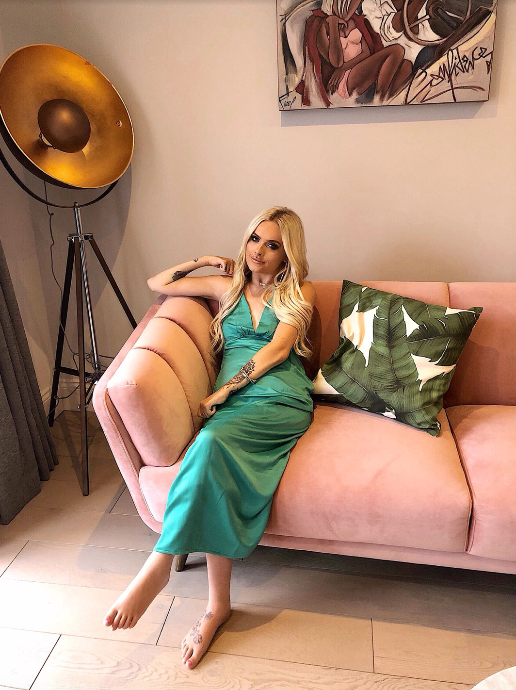 Jordan Bone sat on sofa wearing Dancing Leopard Venice Dress in Green