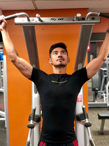 Young man preparing for another round of chin-ups in the gym working out in Brubeck Body Guard