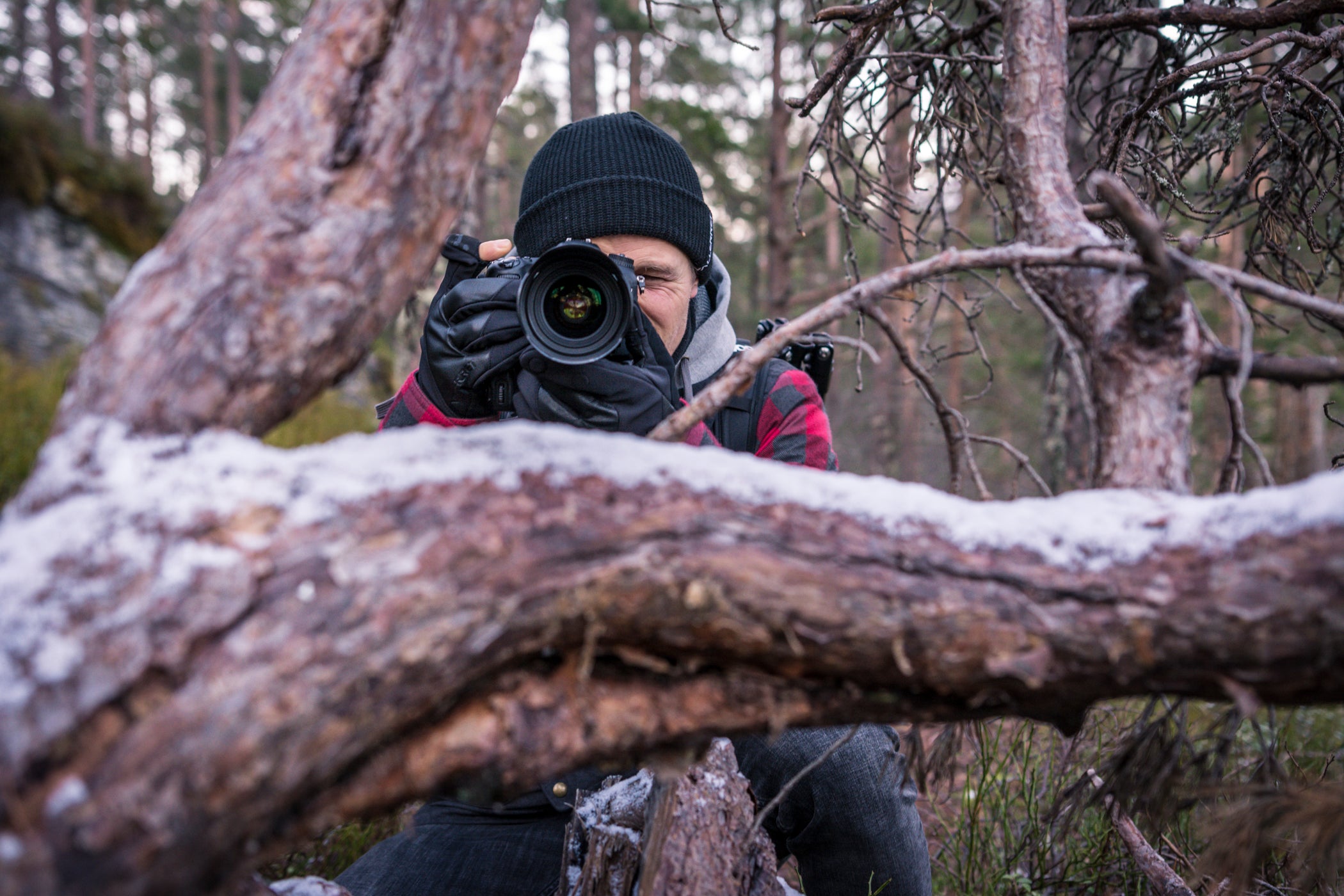 A person taking a photo in a snowy forest