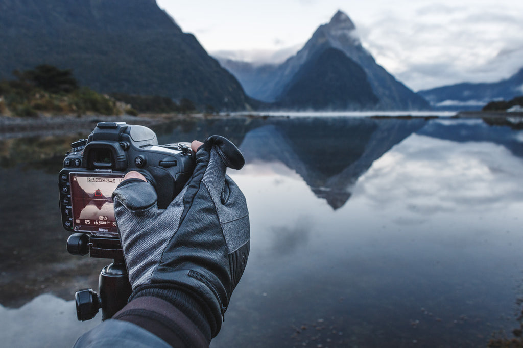 person taking a photo in milford sound