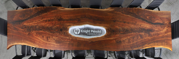 Claro Walnut live edge table photo from above show lit LED branding piece