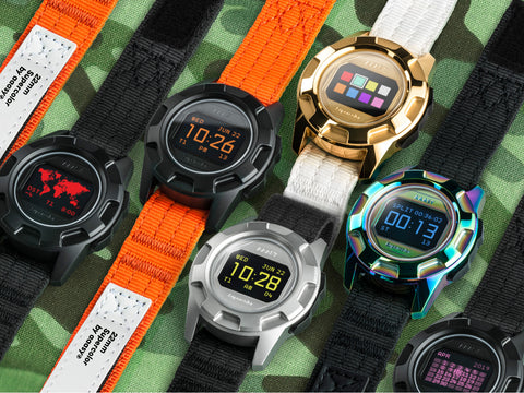 A group of AAASY digital watches laying flat on a camo green background