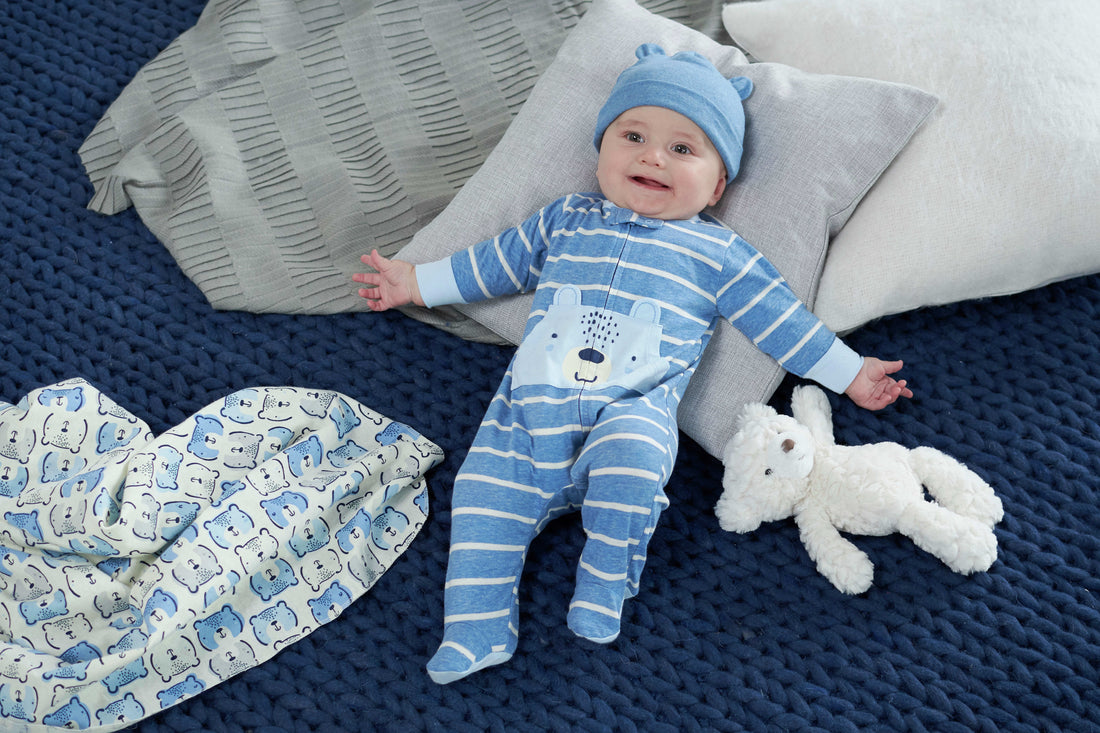 baby laying on blue blanket in blue and white oufit