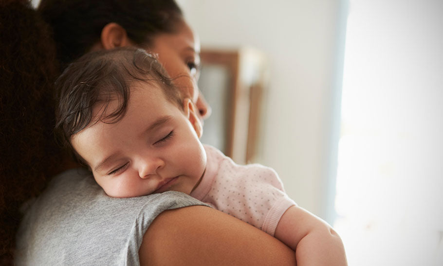 baby napping on mother's shoulder