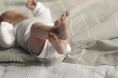 newborn lying down feet up in air
