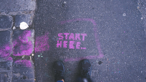 Start here text on a cement ground