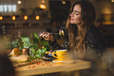 Woman happily eats greens