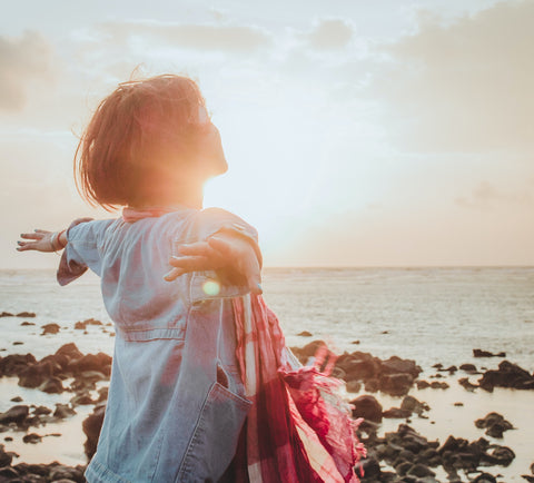 Woman with arms spread during sunrise