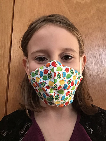 young girl wearing non-medical face mask with multicolour turtle print