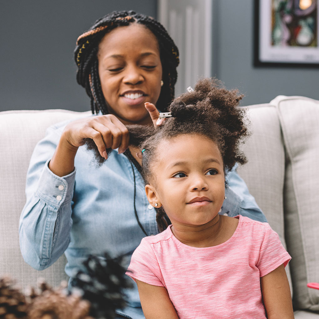 Mother working on daughters hair