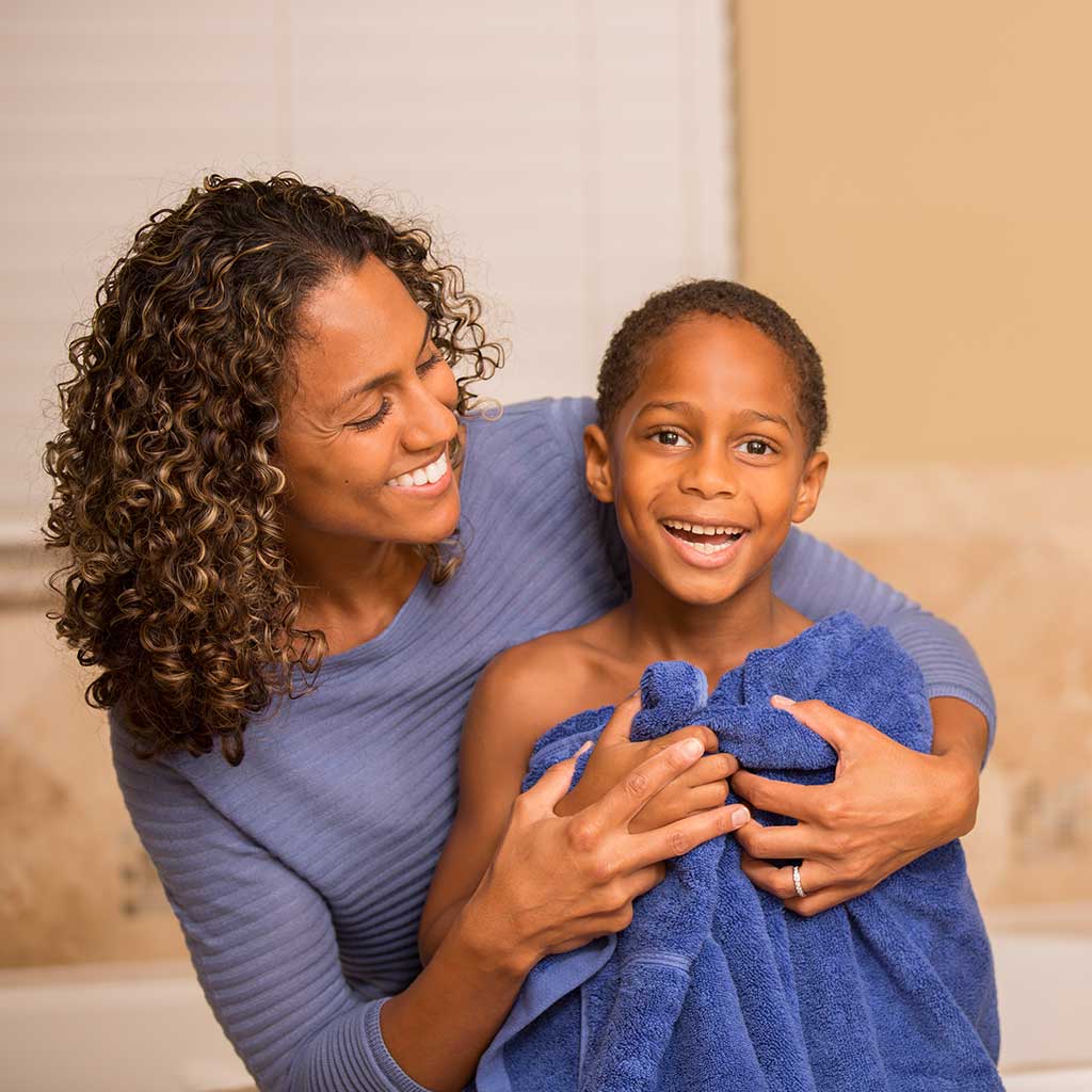 Mother towel drying off her son after his bath